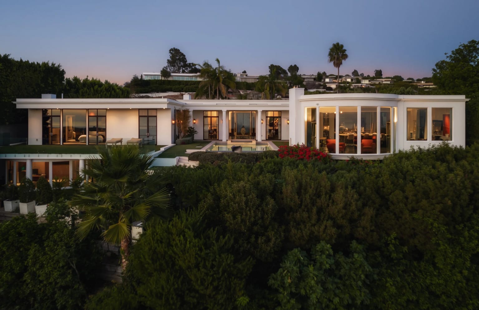 The residence at dusk on its Trousdale Estates promontory