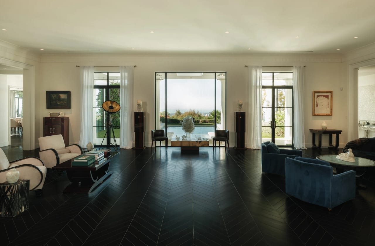 Living room with chevron wood floors and walls of glass